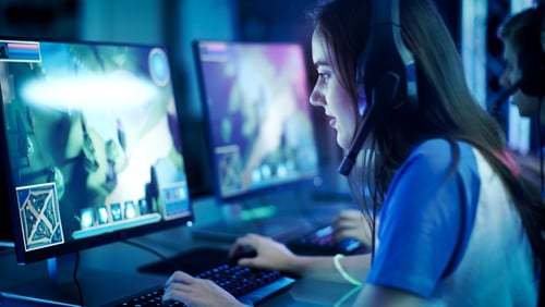 Professional Girl Gamer Plays in MMORPG/ Strategy Video Game on Her Computer.